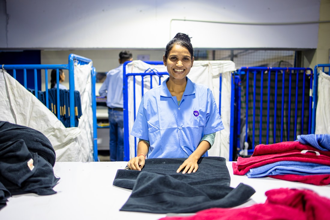 A smiling Zippidobi MOM folding fresh laundry at a local facility